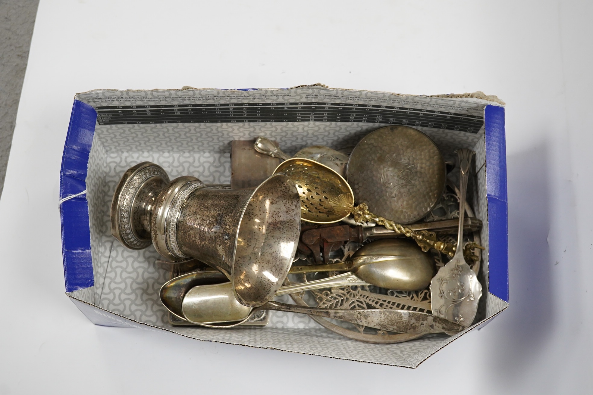 A 19th century Austro Hungarian white metal vase, 11.7cm and other items including a silver gilt spoon, silver stilton scoop, silver match sleeve, silver inlaid glass mats and plated items etc. Condition - poor to fair